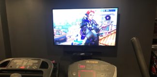 Working out while playing video games Overwatch on elliptical machine