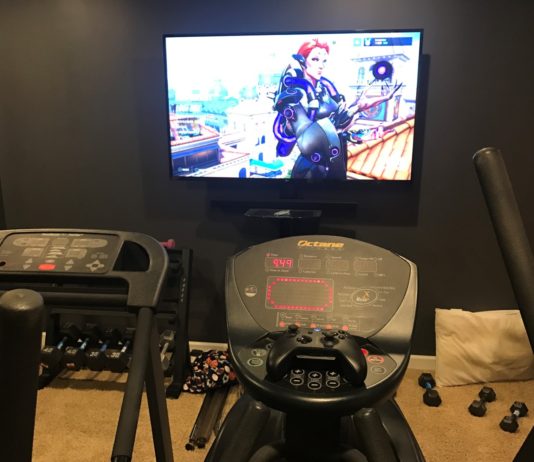 Working out while playing video games Overwatch on elliptical machine
