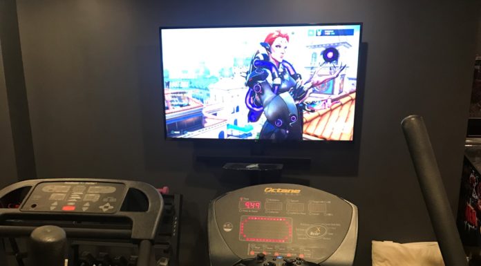 Working out while playing video games Overwatch on elliptical machine